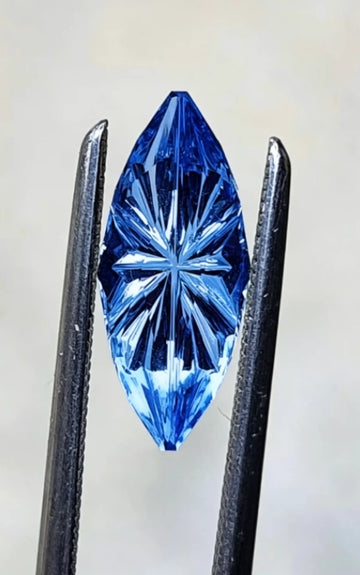 Matthew-1.5ct marquise-cut blue sapphire center stone, flanked by a pair of pear-cut white diamond side stones (0.6ct total), set in platinum
